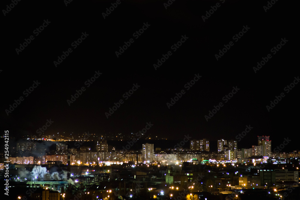 Night city skyline timelapse. Top aerial panoramic view of modern city from tower rooftop. Road junction traffic.