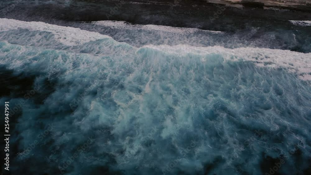 Aerial birds eye view of dramatic dark moody ocean water with white foaming waves breaking Aerial birds eye view of dramatic dark moody ocean water with white foaming waves breaking