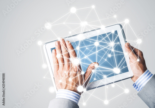 Hands of businessman holding tablet pc with blank screen and connection concept