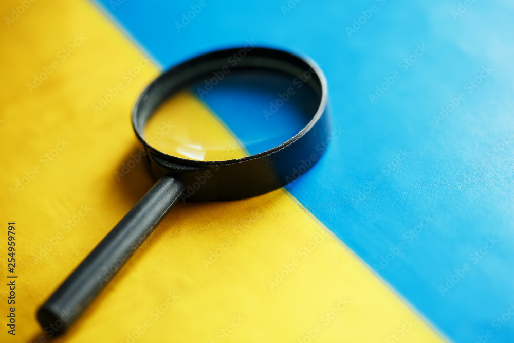 UKRAINE flag looking through a magnifying glass. Spying and monitoring Ukraine. Monitoring the state of the Ukrainian people UKRAINE flag looking through a magnifying glass. Spying and monitoring Ukraine. Monitoring the state of the Ukrainian people