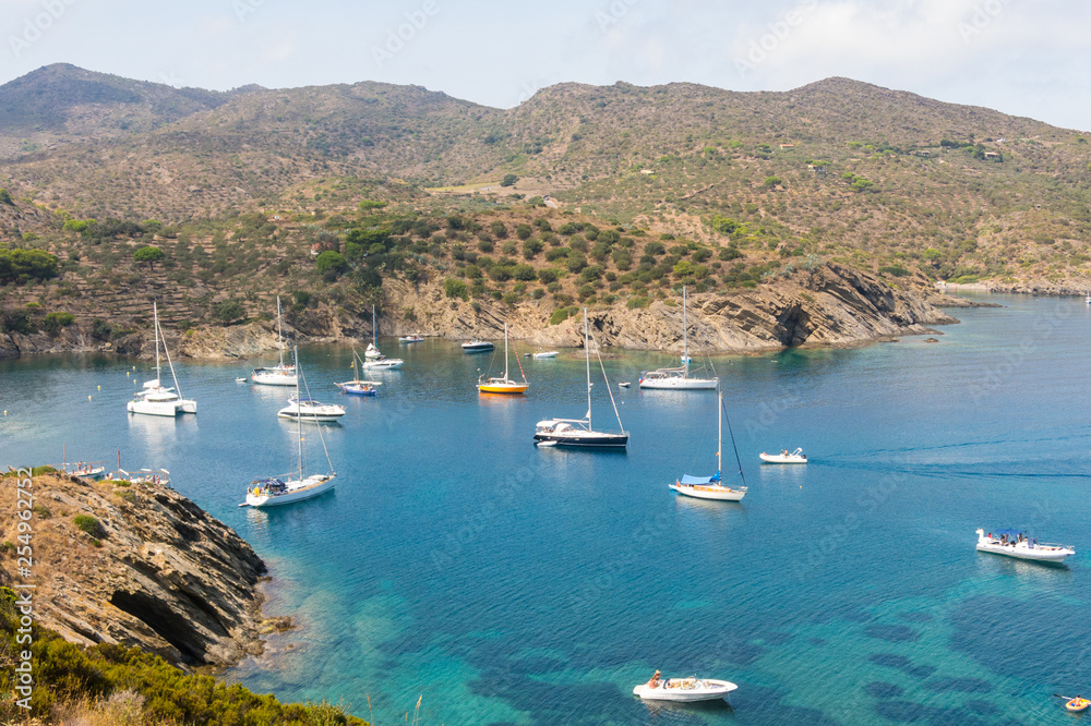 Boats and sailboats moored in a small bay in the Cap de Creus Natural Park. Costa Brava, Catalonia, Spain.