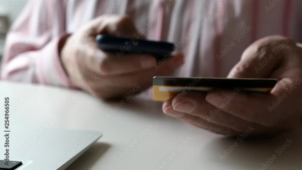 An Elderly Man Shopping Online At Mobile Phone With Credit Card. Slider Shot. An Elderly Man Shopping Online At Mobile Phone With Credit Card. Slider Shot.