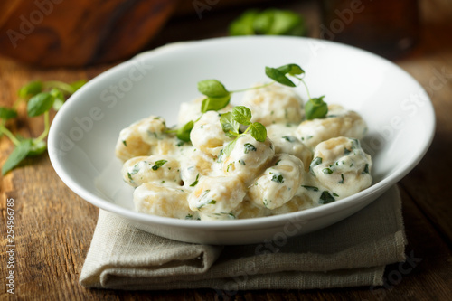 Homemade potato gnocchi with creamy basil sauce