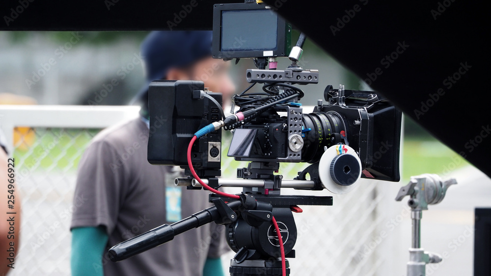 Video camera in film or movie production on tripod and professional gear which shooting in location or studio with crew team and beautiful prop or set and ready to online live broadcast or tv on air