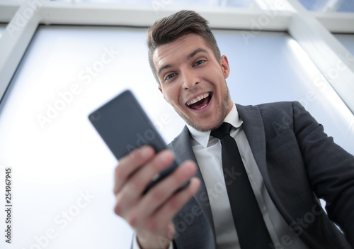 happy businessman with phone looking at camera