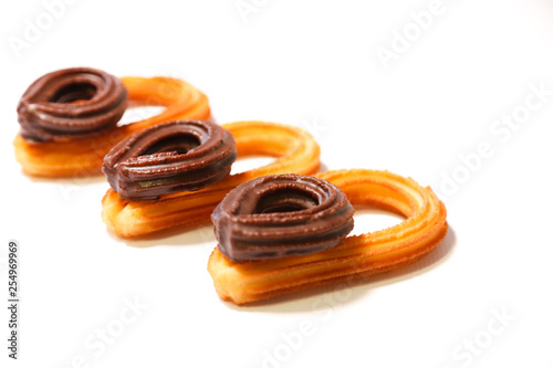 spanish fritters with small chocolate fritters on top on white background
