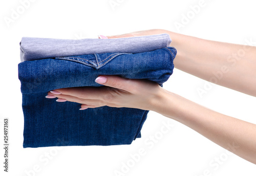 folded jeans and gray t-shirt in hand on white background isolation