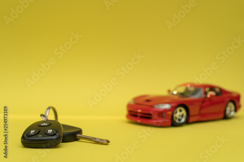 Car keys on yellow background. Red car purchase
