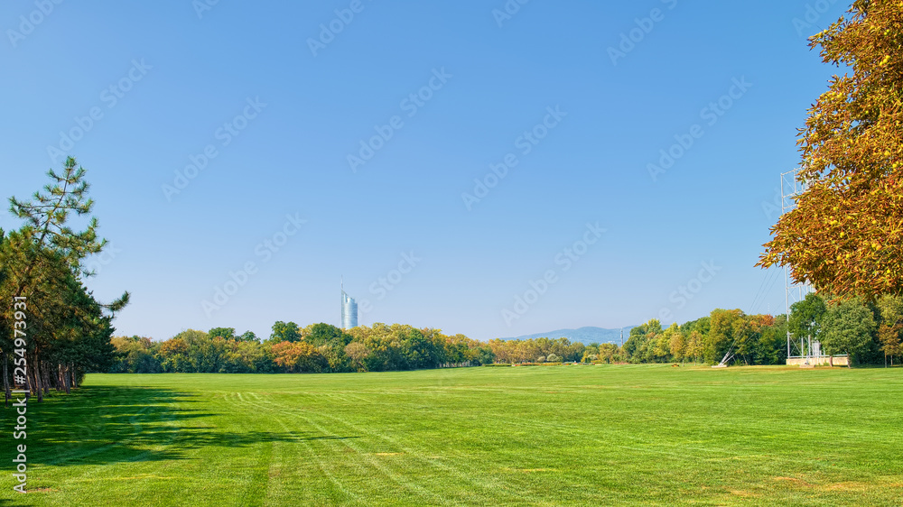 Landscape of Donau park in Vienna, Austria, at the beginning of autumn, when greenery just starts to change color.