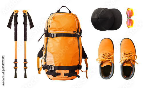 Flat lay of sport equipment and clothes for hiking and trekking. Top view of walking poles, backpack, boots, etc. isolated on white background