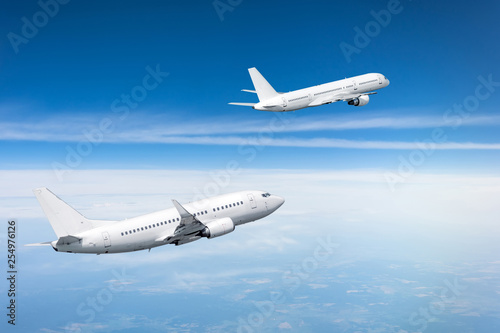 Two passenger aircraft gain altitude after take off.