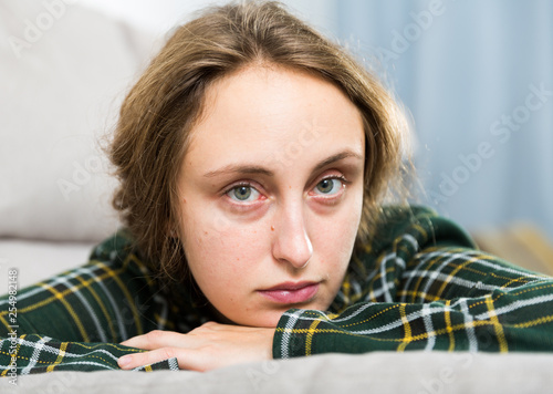 Portrait of sorrowful woman sitting at home