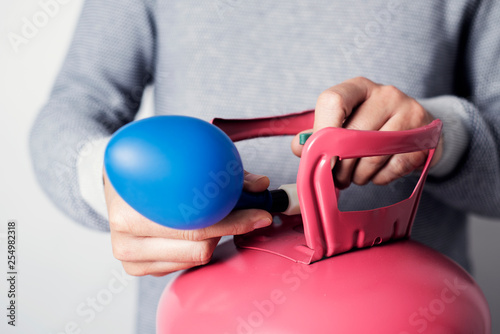 inflating a balloon with helium from a cylinder