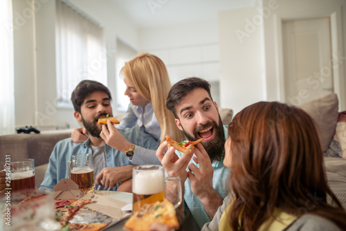 Group of happy young people eating pizza