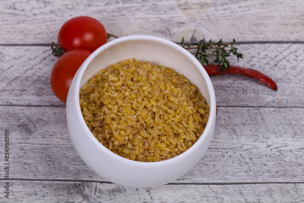 Raw bulgur in the bowl with tomatoes and garlic Raw bulgur in the bowl with tomatoes and garlic