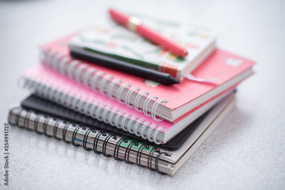 pink notebooks are spiral-bound in a pile on the table pink notebooks are spiral-bound in a pile on the table