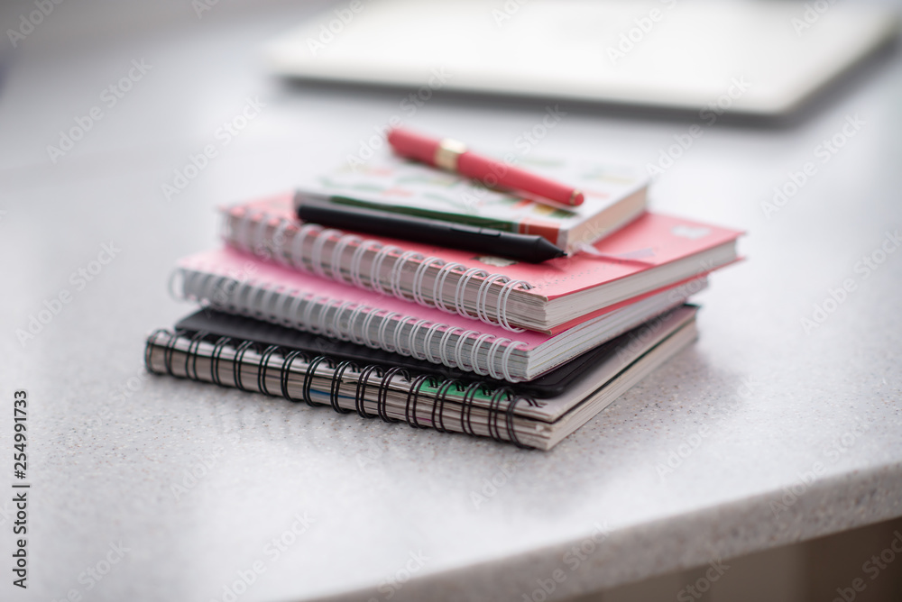 pink notebooks are spiral-bound in a pile on the table pink notebooks are spiral-bound in a pile on the table