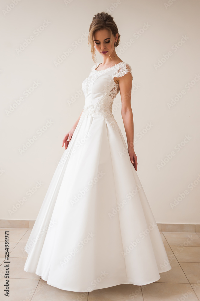Fashion bride in gorgeous wedding dress studio portrait. Beautiful model with bridal makeup and hairstyle in marriage lace dress. Fashion bride in gorgeous wedding dress studio portrait. Beautiful model with bridal makeup and hairstyle in marriage lace dress.