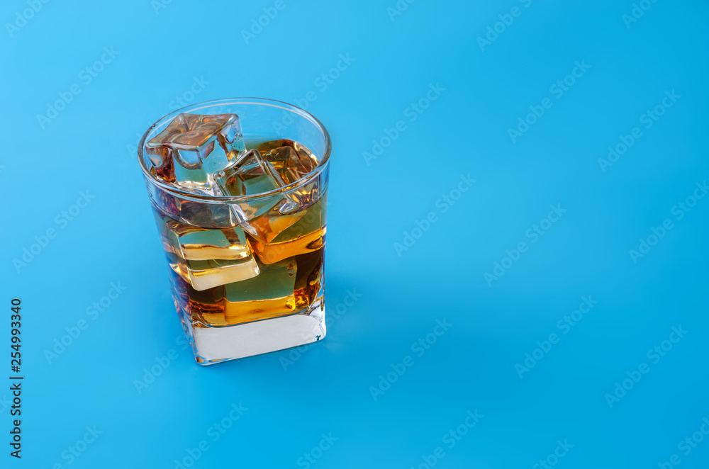 Alcohol in a glass with pastel blue background