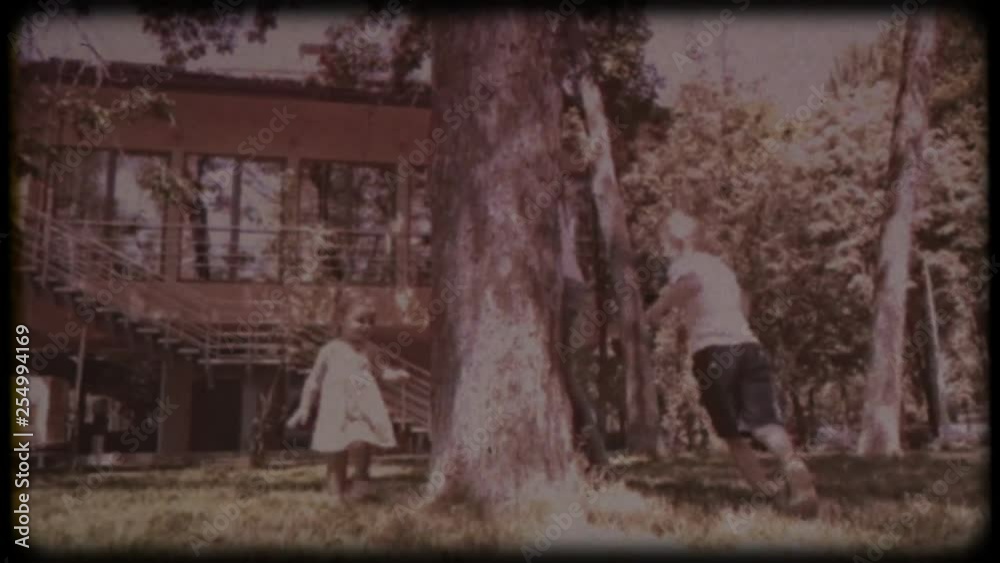 Family video archive. Retro camera 8 mm. Old film. Young father playing with his little daughter and son near the house. Family games. Holiday, holidays. Family together