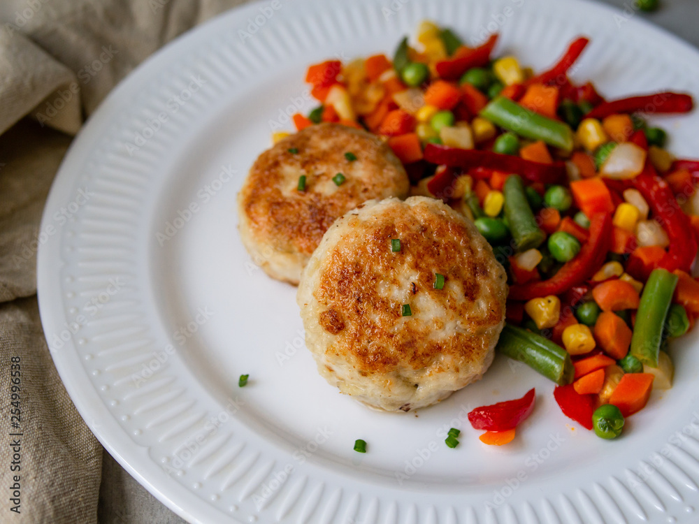 Chicken cutlets with steamed Mix vegetables, Chicken meat balls on white plate. Heathy lunch, diet food. Selective focus, close up.