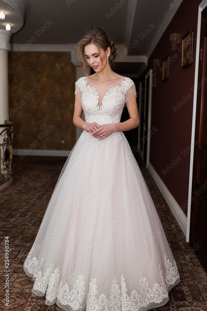 Beauty portrait of bride wearing fashion wedding dress with feathers with luxury delight make-up and hairstyle studio indoor photo. Beauty portrait of bride wearing fashion wedding dress with feathers with luxury delight make-up and hairstyle studio indoor photo.