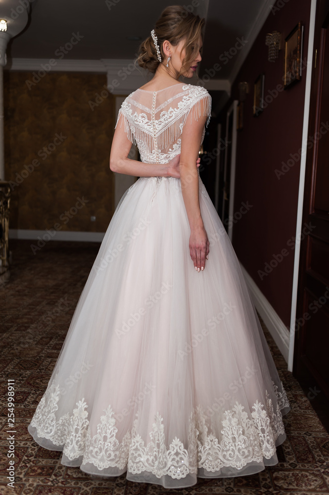 Beauty portrait of bride wearing fashion wedding dress with feathers with luxury delight make-up and hairstyle studio indoor photo. Beauty portrait of bride wearing fashion wedding dress with feathers with luxury delight make-up and hairstyle studio indoor photo.