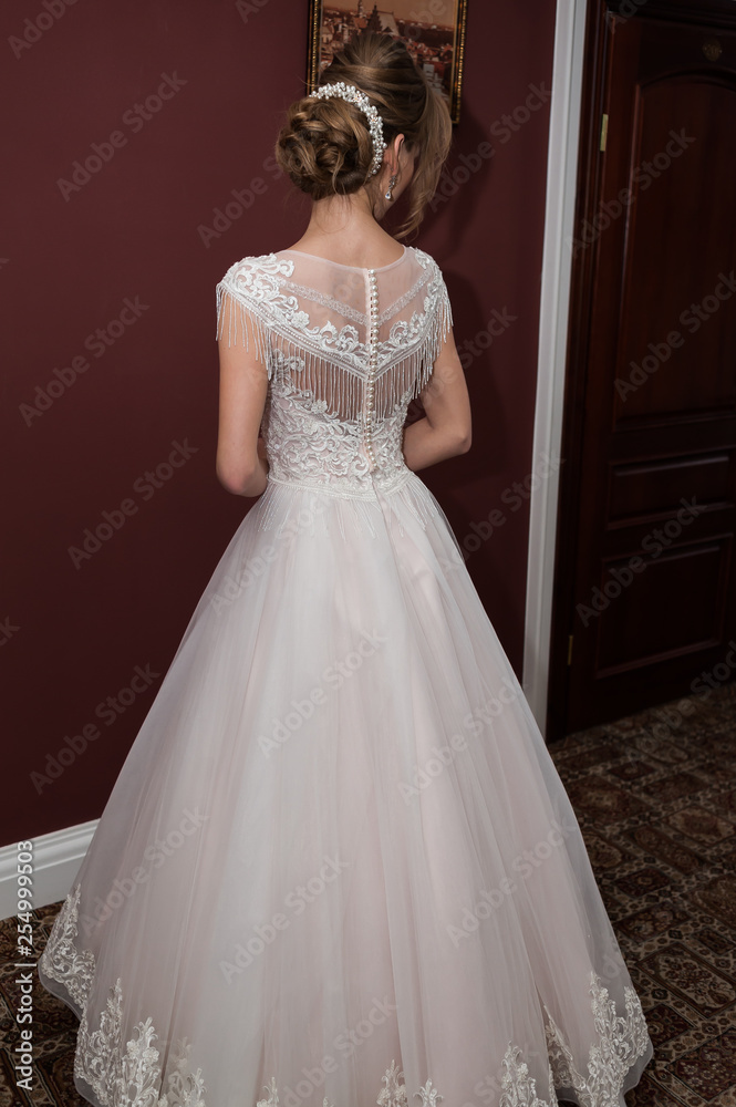 Beauty portrait of bride wearing fashion wedding dress with feathers with luxury delight make-up and hairstyle studio indoor photo. Beauty portrait of bride wearing fashion wedding dress with feathers with luxury delight make-up and hairstyle studio indoor photo.