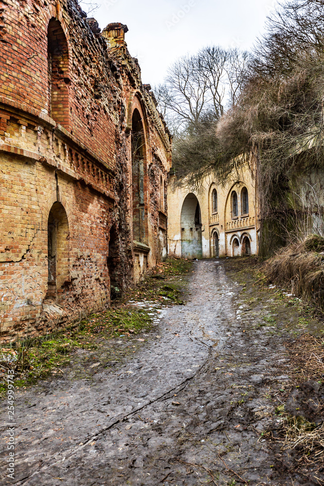 Fototapeta premium Ancient dilapidated military fort in Ukraine with a dirt path and heaps of bricks