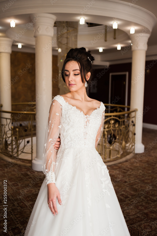 beautiful bride in chic dress. delicate bride with long hair. girl in lace dress with loop in studio Bride%27s morning in a stylish interior