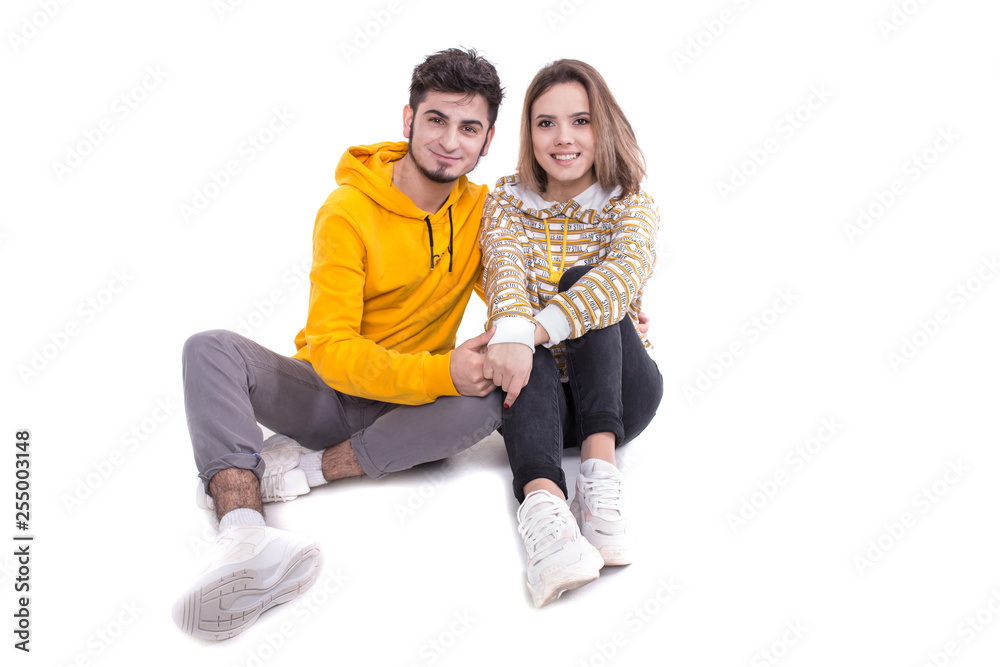 Couple in yellow sitting on white in studio