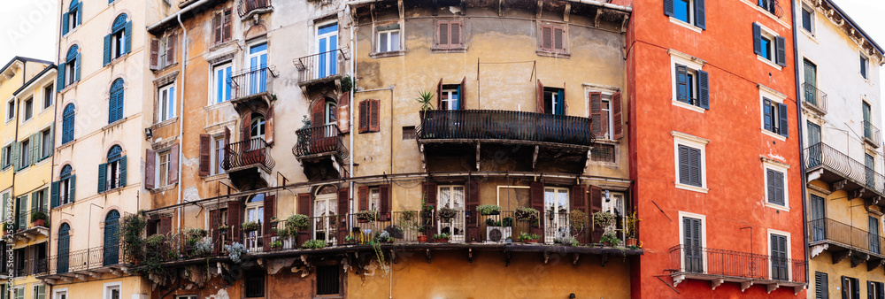Typical old italian building facade in Verona with balconies and flowers