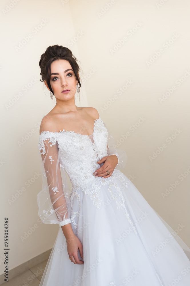 Beautiful bride wearing fashion wedding dress with feathers with luxury delight make-up and hairstyle studio indoor photo shoot Beautiful bride wearing fashion wedding dress with feathers with luxury delight make-up and hairstyle studio indoor photo shoot