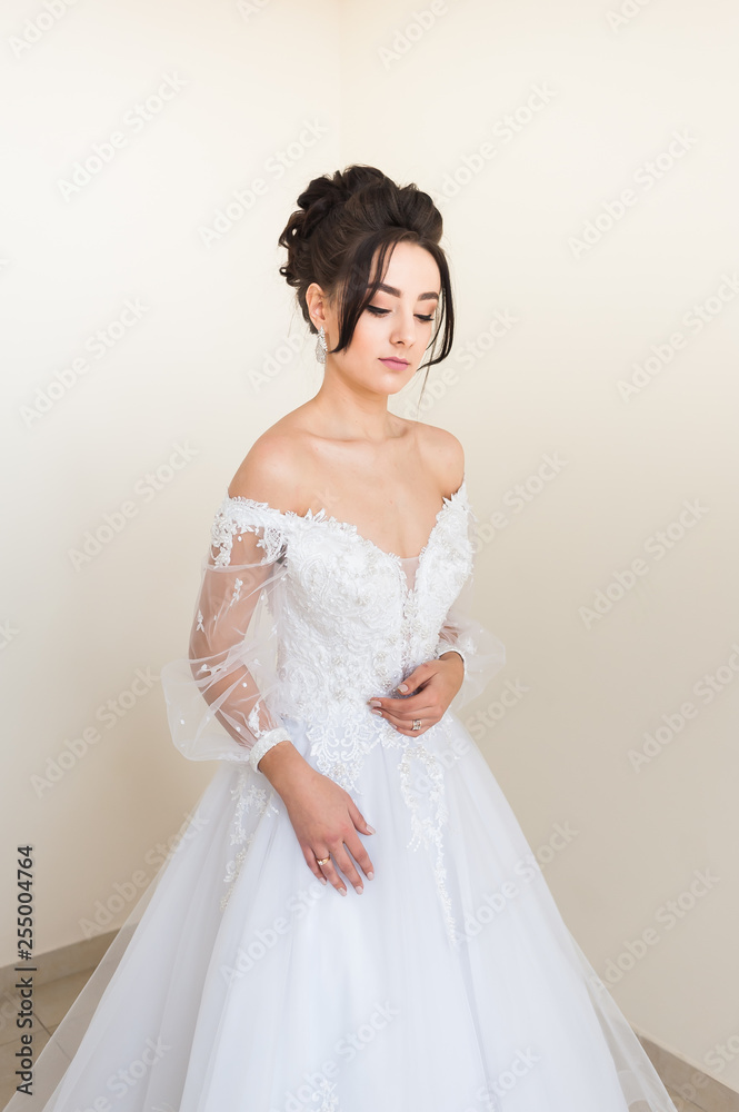 Beautiful bride wearing fashion wedding dress with feathers with luxury delight make-up and hairstyle studio indoor photo shoot Beautiful bride wearing fashion wedding dress with feathers with luxury delight make-up and hairstyle studio indoor photo shoot