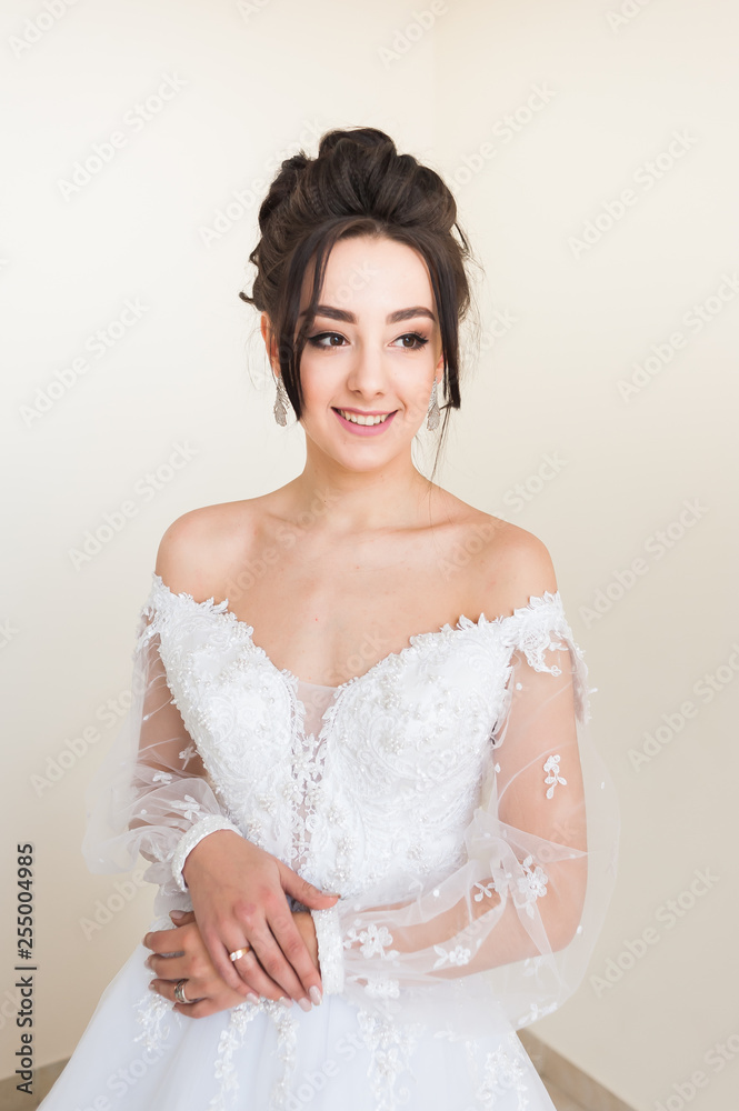 Beautiful bride wearing fashion wedding dress with feathers with luxury delight make-up and hairstyle studio indoor photo shoot Beautiful bride wearing fashion wedding dress with feathers with luxury delight make-up and hairstyle studio indoor photo shoot