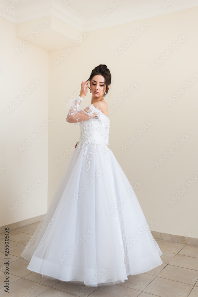 Beautiful bride wearing fashion wedding dress with feathers with luxury delight make-up and hairstyle studio indoor photo shoot Beautiful bride wearing fashion wedding dress with feathers with luxury delight make-up and hairstyle studio indoor photo shoot