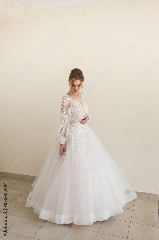 Beautiful bride wearing fashion wedding dress with feathers with luxury delight make-up and hairstyle, studio indoor photo shoot Beautiful bride wearing fashion wedding dress with feathers with luxury delight make-up and hairstyle, studio indoor photo shoot
