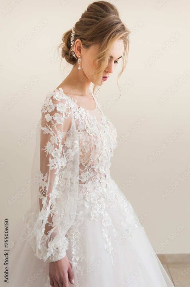 Beautiful bride wearing fashion wedding dress with feathers with luxury delight make-up and hairstyle, studio indoor photo shoot Beautiful bride wearing fashion wedding dress with feathers with luxury delight make-up and hairstyle, studio indoor photo shoot