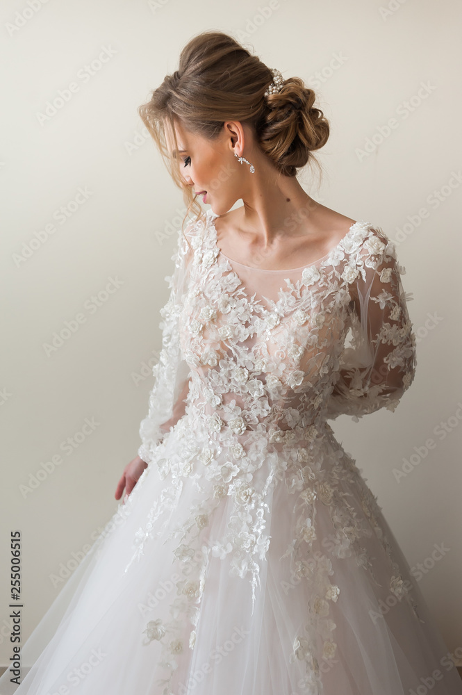 Beautiful bride wearing fashion wedding dress with feathers with luxury delight make-up and hairstyle, studio indoor photo shoot Beautiful bride wearing fashion wedding dress with feathers with luxury delight make-up and hairstyle, studio indoor photo shoot