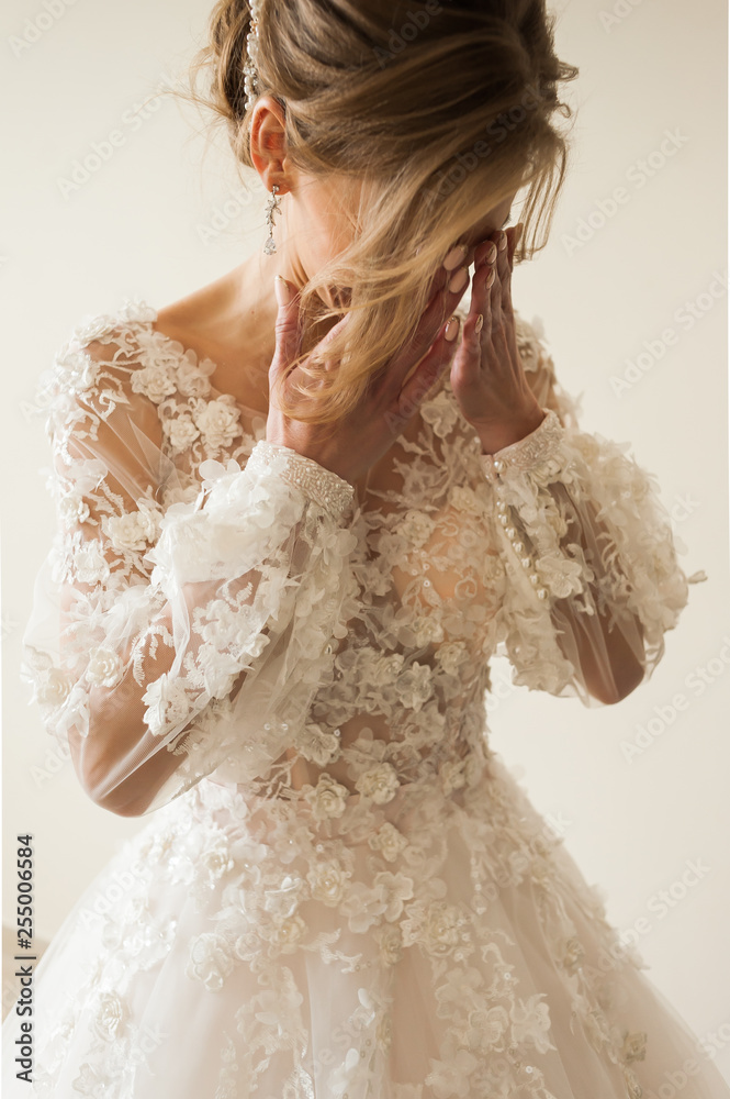 Beautiful bride wearing fashion wedding dress with feathers with luxury delight make-up and hairstyle, studio indoor photo shoot Beautiful bride wearing fashion wedding dress with feathers with luxury delight make-up and hairstyle, studio indoor photo shoot