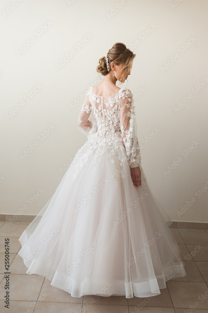 Beautiful bride wearing fashion wedding dress with feathers with luxury delight make-up and hairstyle, studio indoor photo shoot Beautiful bride wearing fashion wedding dress with feathers with luxury delight make-up and hairstyle, studio indoor photo shoot