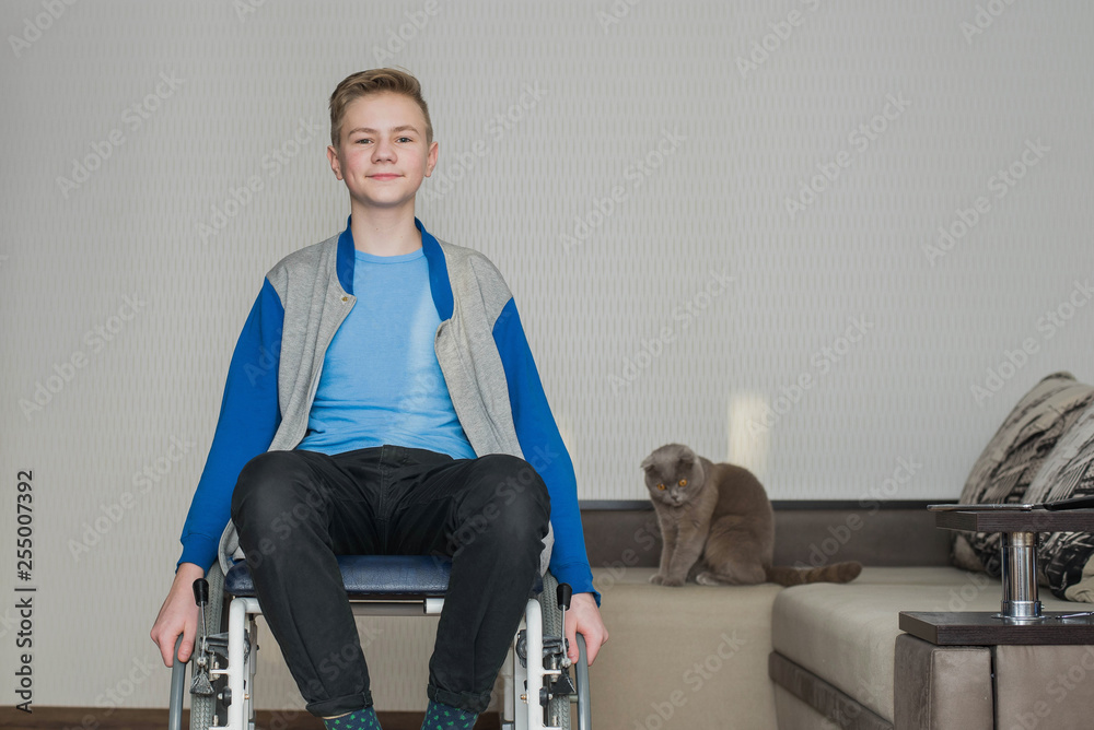 teen boy student sitting in a wheelchair at home. teen boy student sitting in a wheelchair at home.
