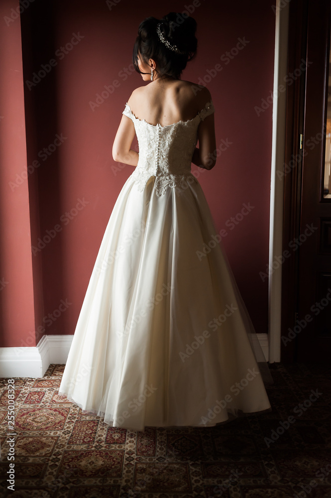 Beauty portrait of bride wearing fashion wedding dress with feathers with luxury delight make-up and hairstyle, studio indoor photo. Beauty portrait of bride wearing fashion wedding dress with feathers with luxury delight make-up and hairstyle, studio indoor photo.
