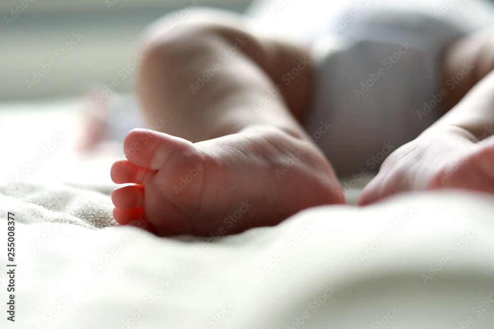 stópki dziecka niemowlaka leżącego w łóżeczku  - obrazy, fototapety, plakaty 