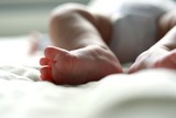 stópki dziecka niemowlaka leżącego w łóżeczku 
