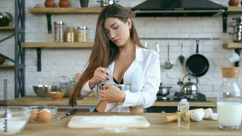 Young woman kneading eggs in the plate. Cooking at the kitchen. Young woman kneading eggs in the plate. Cooking at the kitchen.