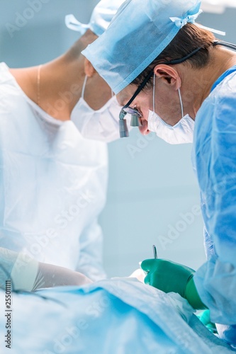 Surgeons perform complex surgery. Vertical photography