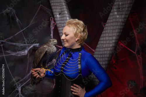 beautiful scary woman with the big hawk best friend on the background of dark room