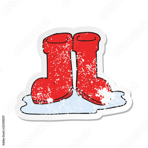 retro distressed sticker of a cartoon wellington boots in puddle