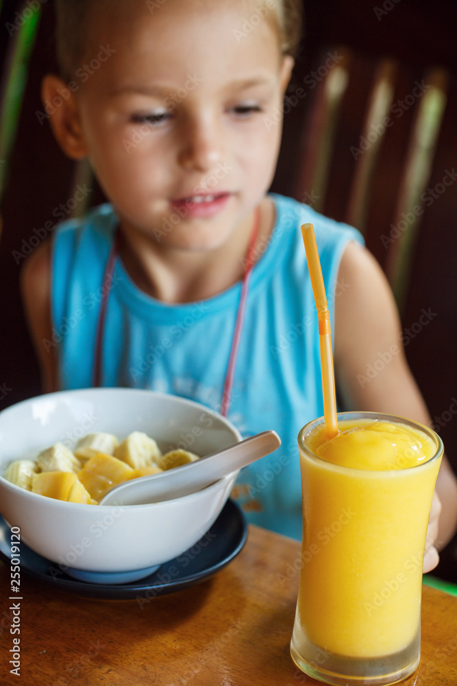 beautiful boy is having breakfast with juice and porridge beautiful boy is having breakfast with juice and porridge